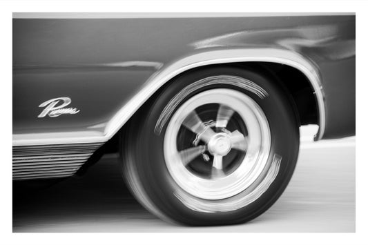 Black and white close-up photograph of a classic car wheel and fender with a visible 'Rome' script emblem on the side.