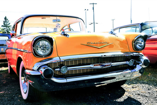 Yellow 57 — fine art print of a classic 1957 Chevrolet Bel Air in bright yellow, orange, and red, parked outdoors among vintage cars, by DC Ward